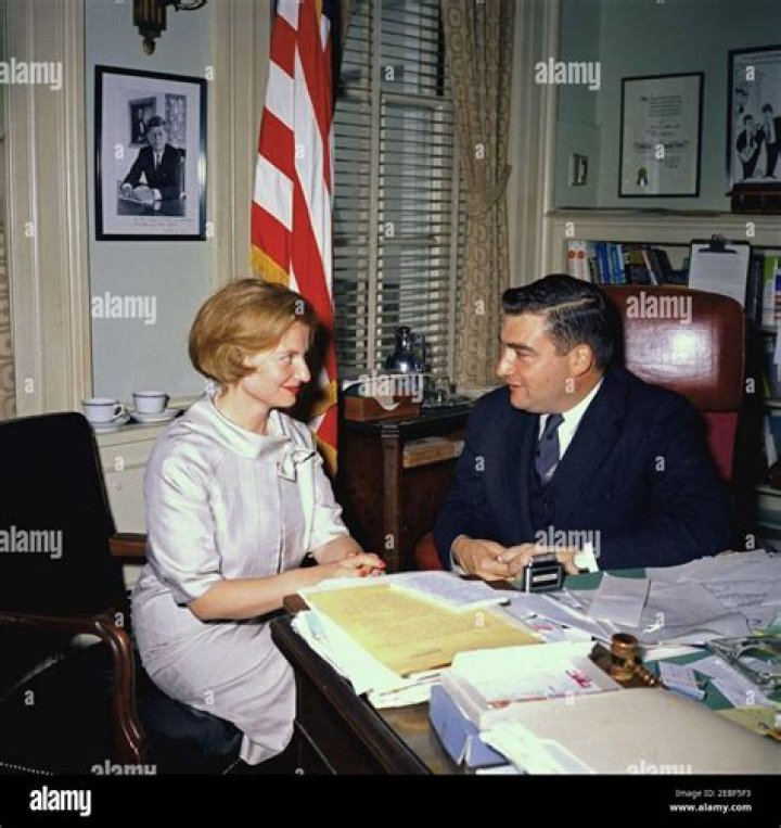 Press Secretary Pierre Salinger in his office with an unidentified journalist